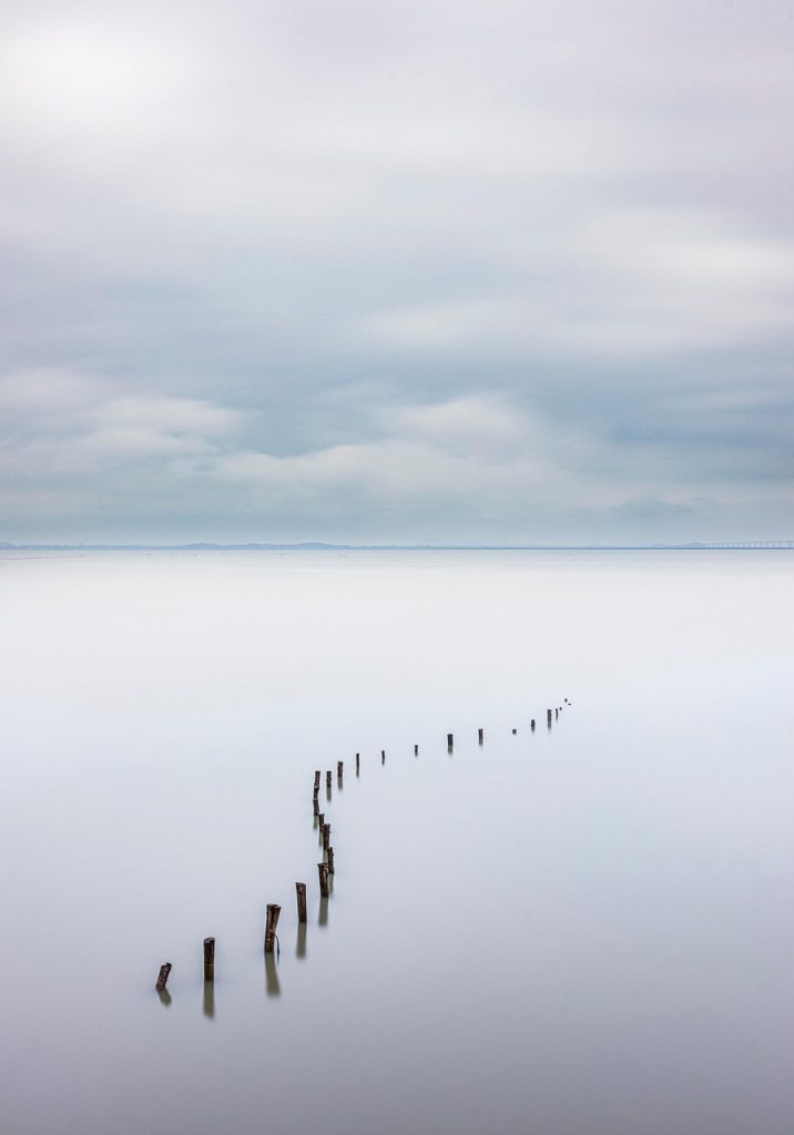 Ruhige Wasserlandschaft mit Pfählen im stillen Wasser