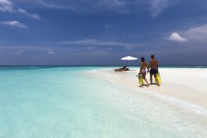 Paar am türkisfarbenen Meer als Symbol für Urlaub und Erholung